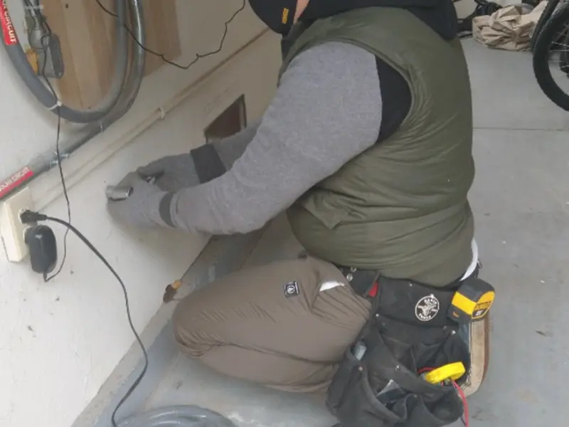 Electrician performing outlet wiring in a Lakewood garage
